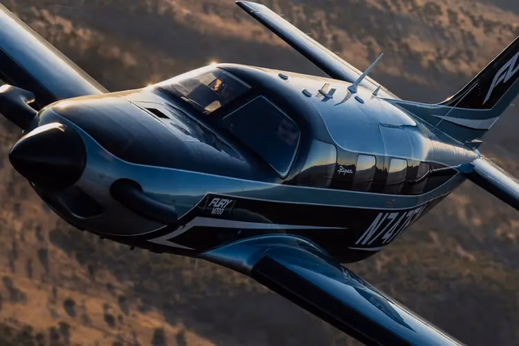 Piper M700 in flight over a mountain landscape