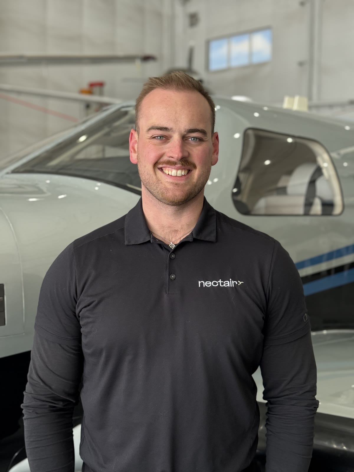 A NectAir pilot beside the aircraft