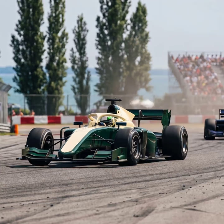 Two race cars at speed on a tree-lined circuit
