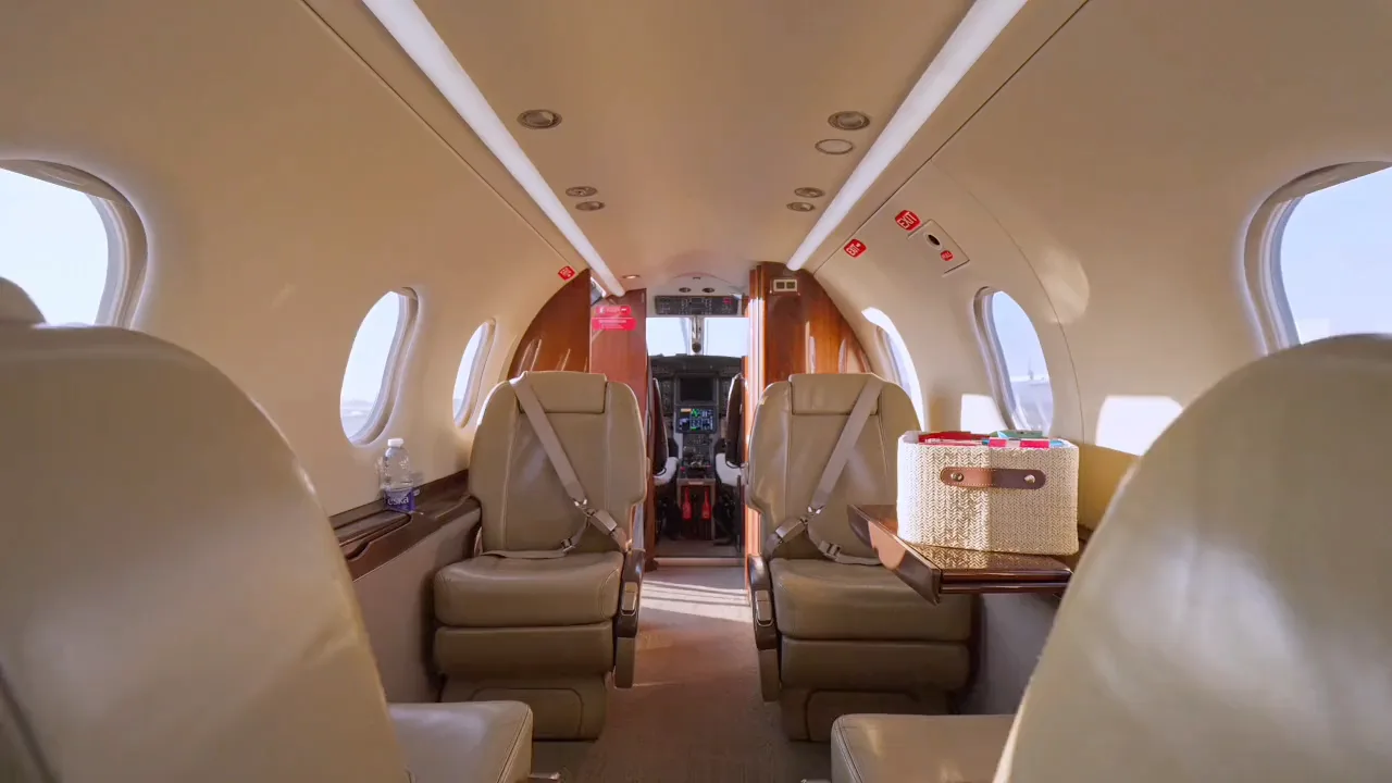 Inside NectAir’s Pilatus PC‑12: executive club seats, a table, and the flight deck beyond