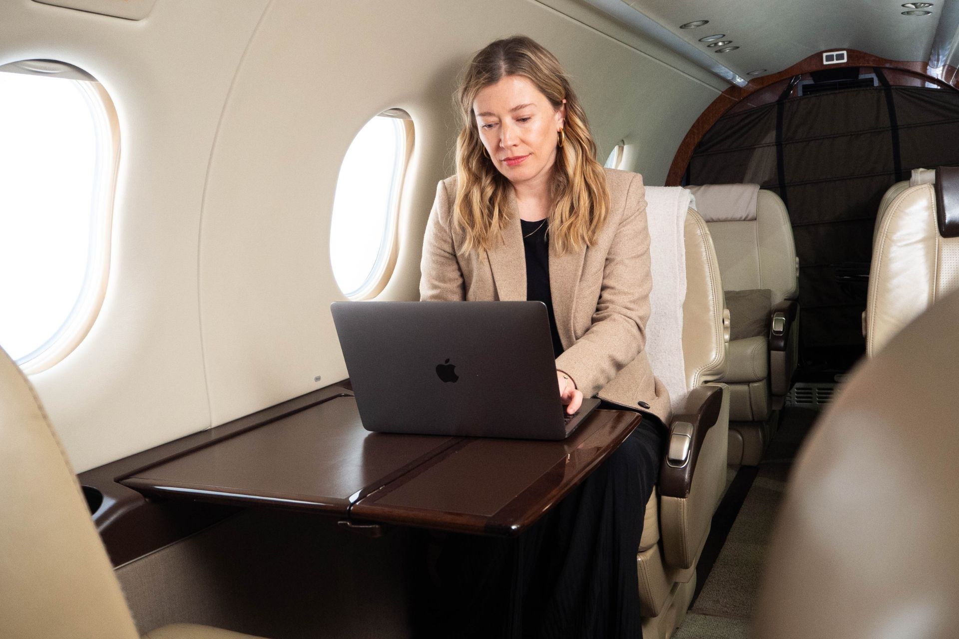 Pilatus PC-12 cabin — passenger working at the laptop workstation